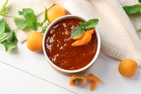 Bowl with sweet apricot jam on white tableの写真素材
