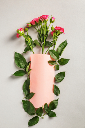 Beautiful rose flowers with blank card on light backgroundの写真素材