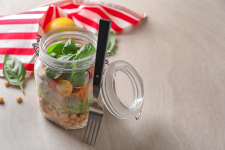 Delicious vegetable salad in mason jar on grey tableの写真素材