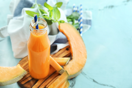 Bottle with delicious melon smoothie on boardの写真素材