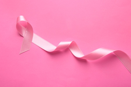 Pink ribbon on color background. Breast cancer conceptの写真素材