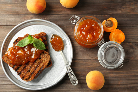 Toasted bread with delicious apricot jam on plateの写真素材