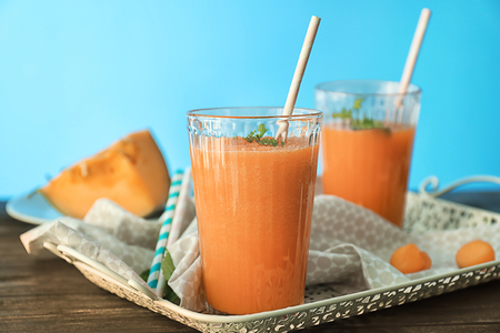 Glasses with delicious melon smoothie on wooden tableの写真素材