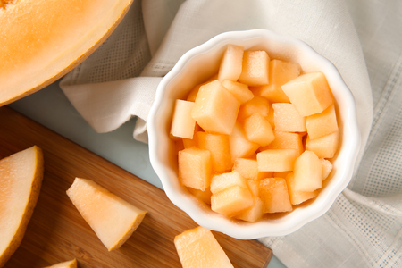 Bowl with pieces of ripe melon on tableの写真素材
