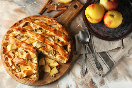 Board with delicious apple pie on tableの写真素材