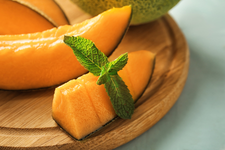 Pieces of tasty cut melon on wooden board, closeupの写真素材