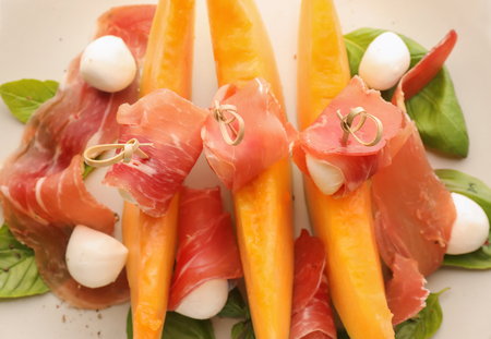 Delicious melon with prosciutto and mozzarella cheese on plate, closeupの写真素材