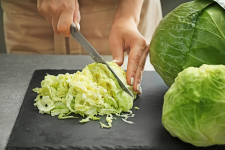 Woman cutting fresh cabbage, closeupの写真素材