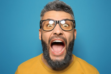 Portrait of screaming man with dyed hair and beard on color backgroundの写真素材