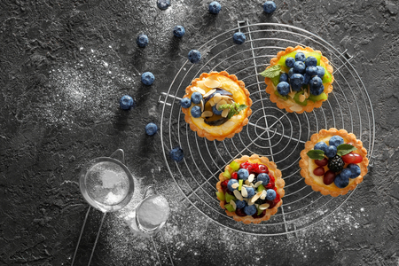 Delicious tarts with fruits and berries on cooling rackの写真素材