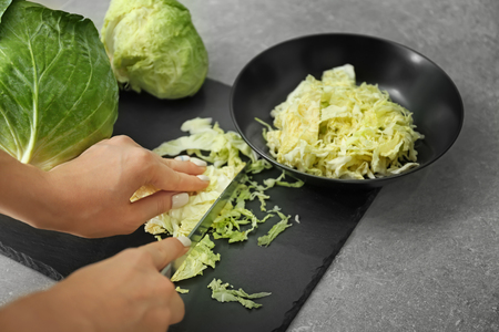 Woman cutting fresh cabbage, closeupの写真素材
