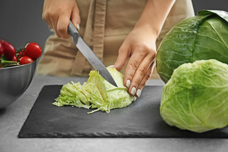 Woman cutting fresh cabbage, closeupの写真素材