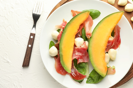 Delicious melon with prosciutto and mozzarella cheese on plateの写真素材