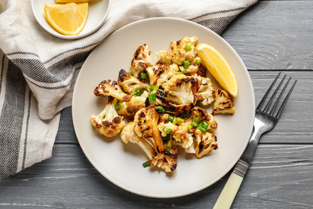 Plate with tasty grilled cauliflower on wooden tableの写真素材