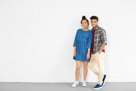 Happy interracial couple in empty room. Moving into new houseの写真素材