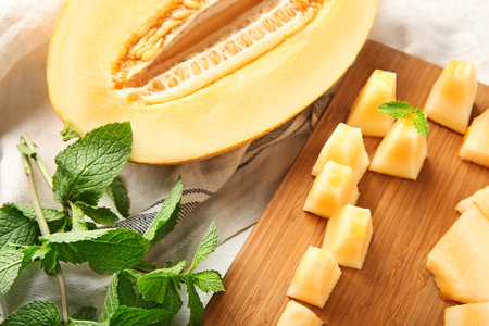 Sliced ripe melon with mint on tableの写真素材