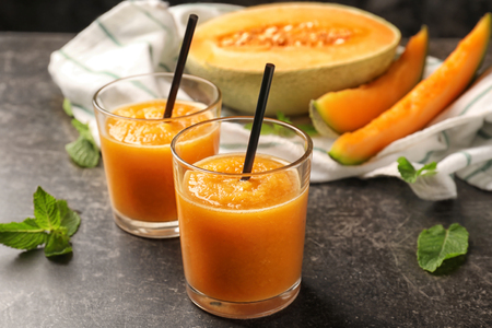 Glasses of fresh melon smoothie on dark tableの写真素材