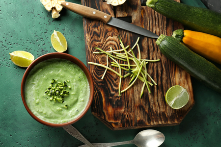 Tasty zucchini soup in bowl on color tableの写真素材