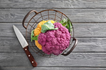 Basket with different cauliflower on wooden tableの写真素材
