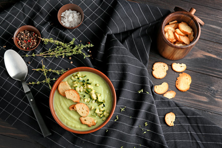 Tasty zucchini soup with croutons in bowl on tableの写真素材
