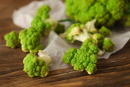 Green cauliflower cabbage on wooden table, closeupの写真素材