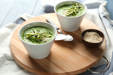 Tasty zucchini soup in bowls on wooden boardの写真素材