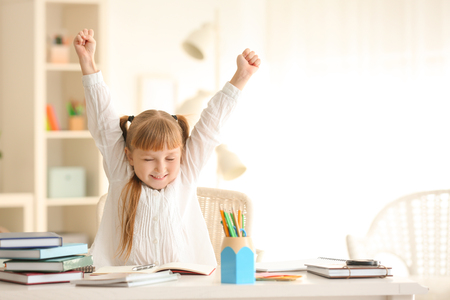 Happy little schoolgirl after finishing her homeworkの写真素材