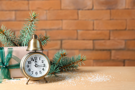 Alarm clock with gift and fir branches on table. Christmas countdownの写真素材