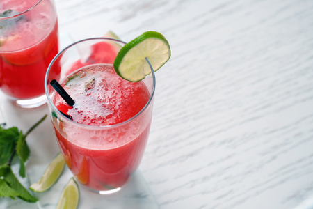Glass with fresh watermelon smoothie on light tableの写真素材