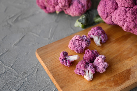 Purple cauliflower on wooden board