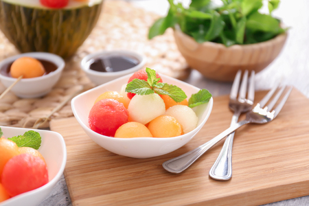 Plate with tasty melon dessert on wooden boardの写真素材