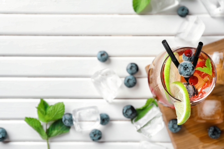 Fresh berry cocktail with lime in glass on white tableの写真素材