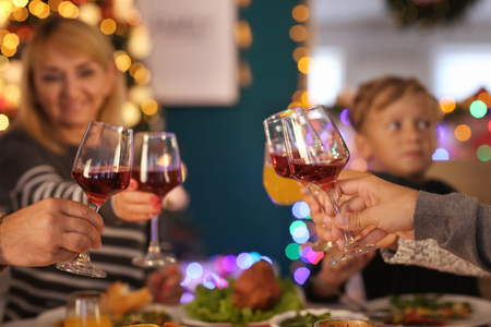 Happy family drinking wine during Christmas dinner at homeの写真素材