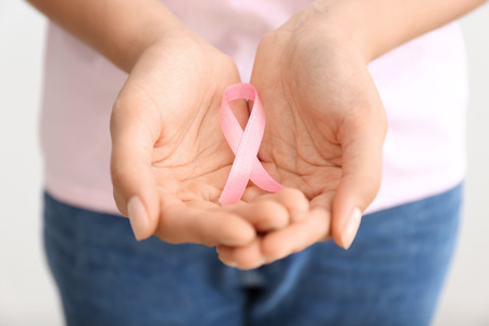 Woman holding pink ribbon, closeup. Breast cancer conceptの写真素材