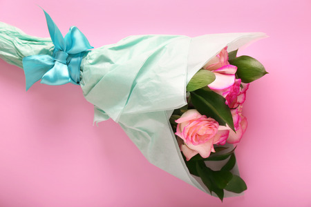 Bouquet of beautiful roses on color tableの写真素材