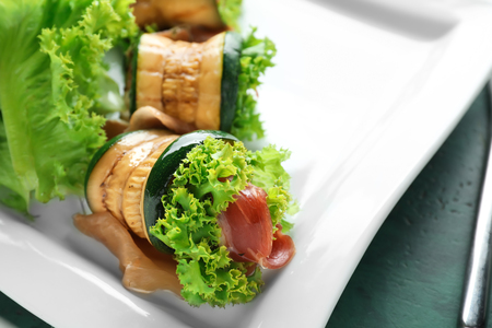 Tasty zucchini rolls with prosciutto on plate, closeupの写真素材