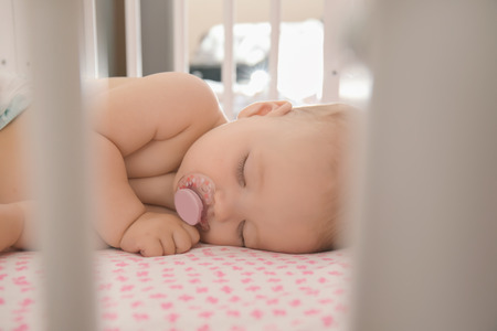 Cute little baby sleeping in cribの写真素材