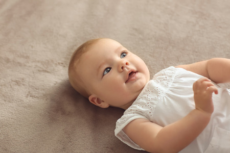 Cute little baby lying on bedの写真素材
