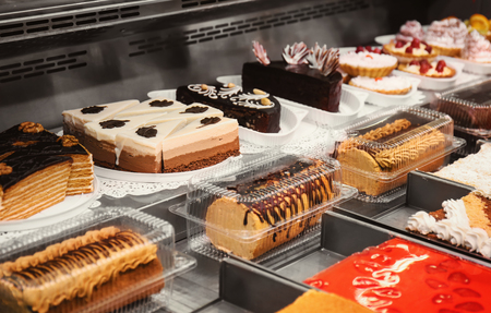 Refrigerated display case with delicious desserts in supermarketの写真素材