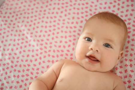 Portrait of cute little baby lying in cribの写真素材