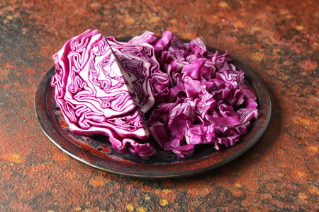 Plate with cut red cabbage on color tableの写真素材