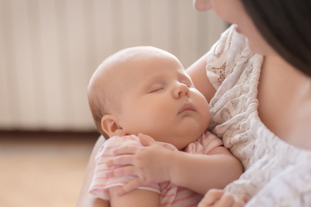 Mother with her sleeping baby at homeの写真素材