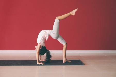 Little girl practicing yoga indoors