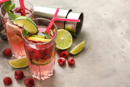 Glasses of fresh raspberry mojito on light tableの写真素材