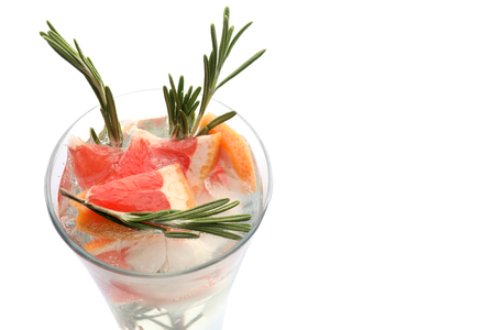 Fresh grapefruit cocktail with rosemary in glass on white backgroundの写真素材