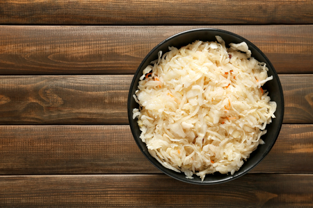 Bowl with delicious sauerkraut on wooden tableの写真素材