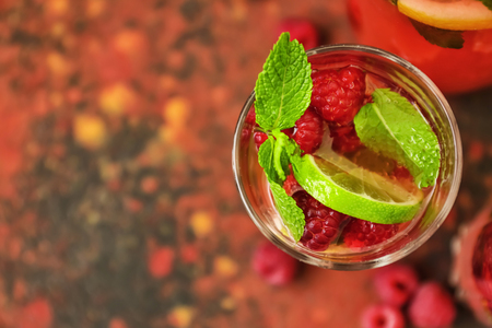 Glass of fresh raspberry mojito on color table, closeupの写真素材