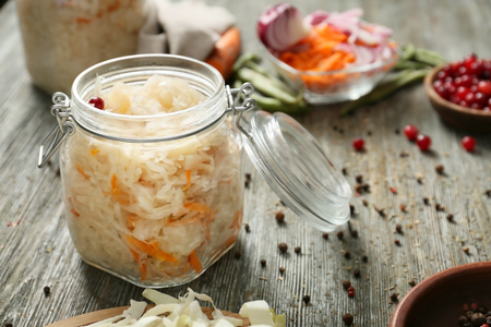 Glass jar with homemade sauerkraut on wooden tableの写真素材