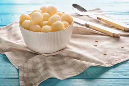 Bowl with tasty melon balls on wooden tableの写真素材
