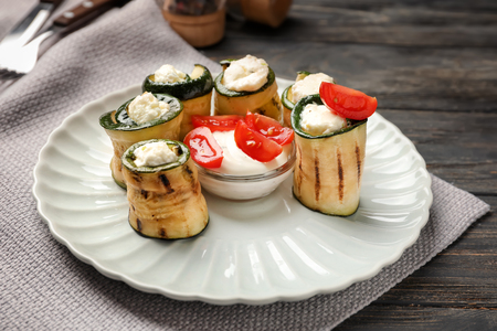 Tasty zucchini rolls with cheese and sauce on plateの写真素材